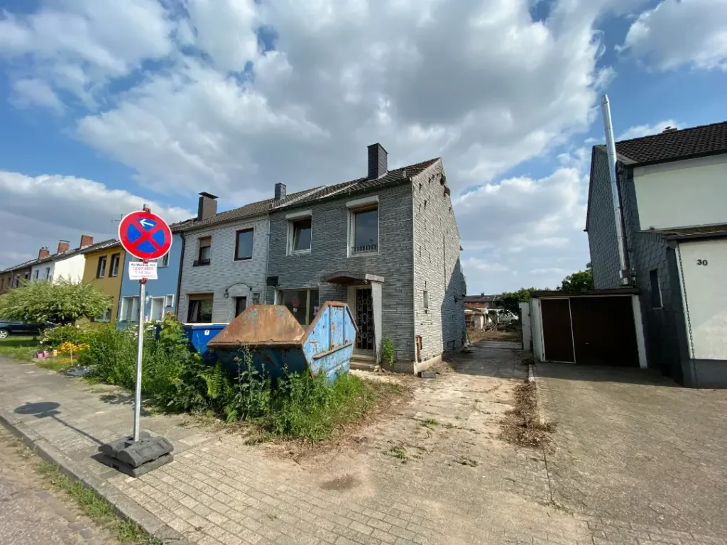 Baufälliges Reihenendhaus mit Container vor dem Haus vor Entkernung und Altbausanierung