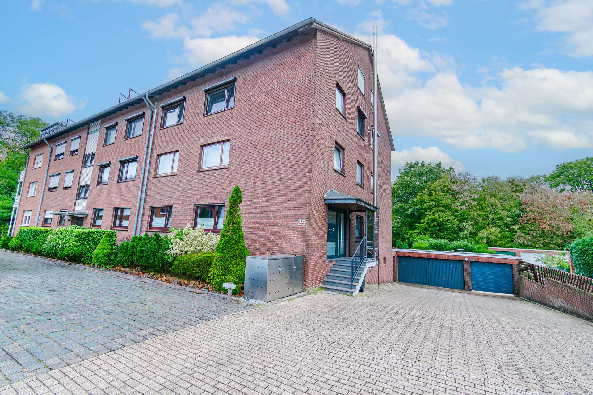 Hausansicht - Besonderes Wohngefühl: Modernisierte Maisonettewohnung mit privatem Garten & Garage in Grünlage